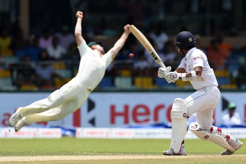 Australian cricketer Marsh (L) jumps, attempting to catch a ball off the batting of Sri Lanka cricketer Dinesh Chandimal.