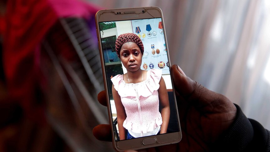 A close up of a young Nigerian woman on a smartphone.
