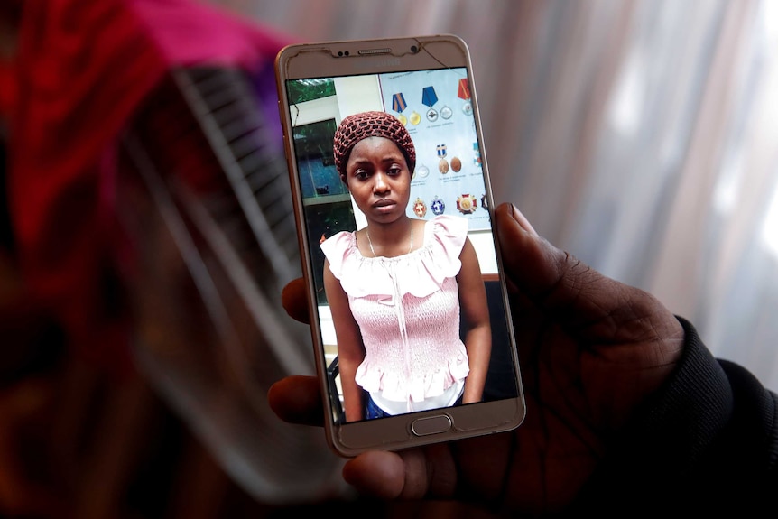 A close up of a young Nigerian woman on a smartphone.