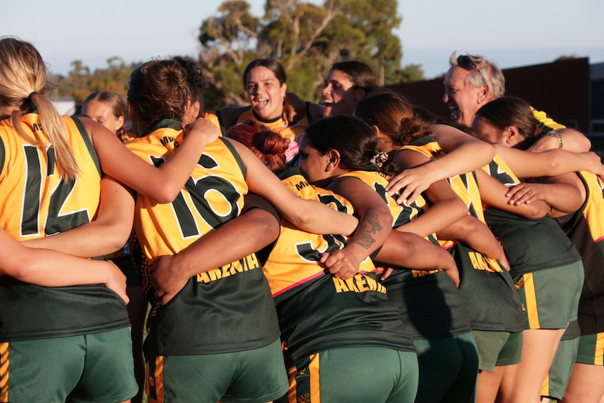 About ten players in a circle huddling.