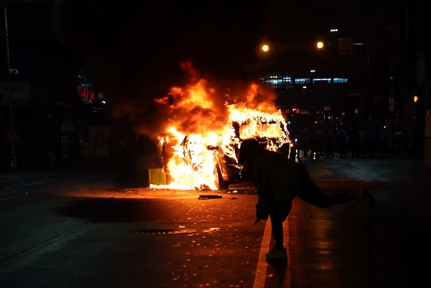 A police car burns during a protest.