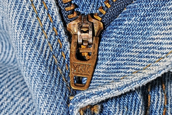 Blue denim fabric with a brass YKK-brand zip