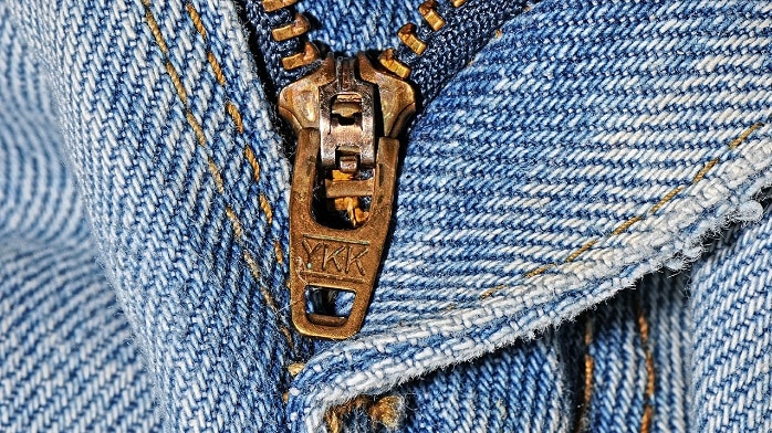 Blue denim fabric with a brass YKK-brand zip