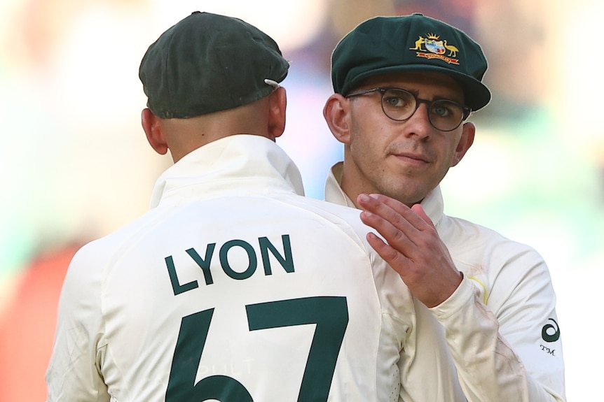 Tood Murphy looks over Nathan Lyon's shoulder as they hug