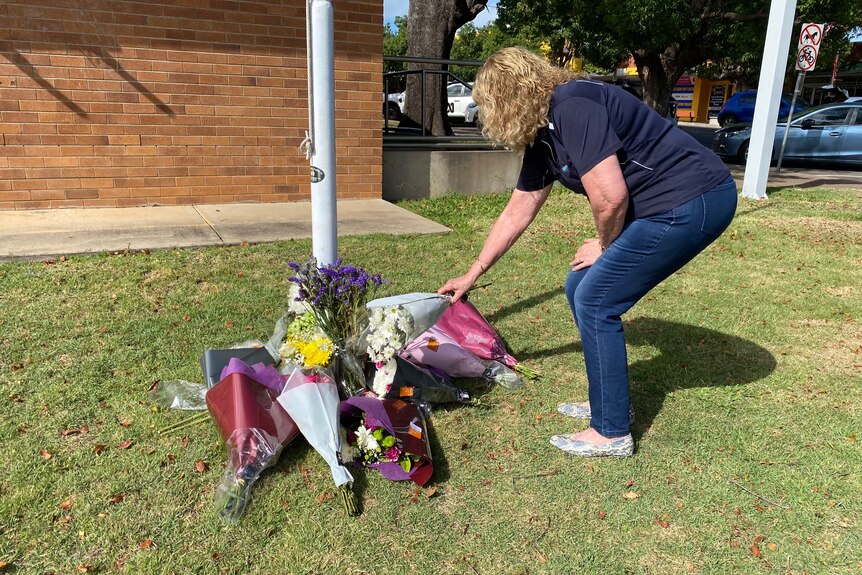 Locals laid flowers under the flagpole at Chinchilla police station.