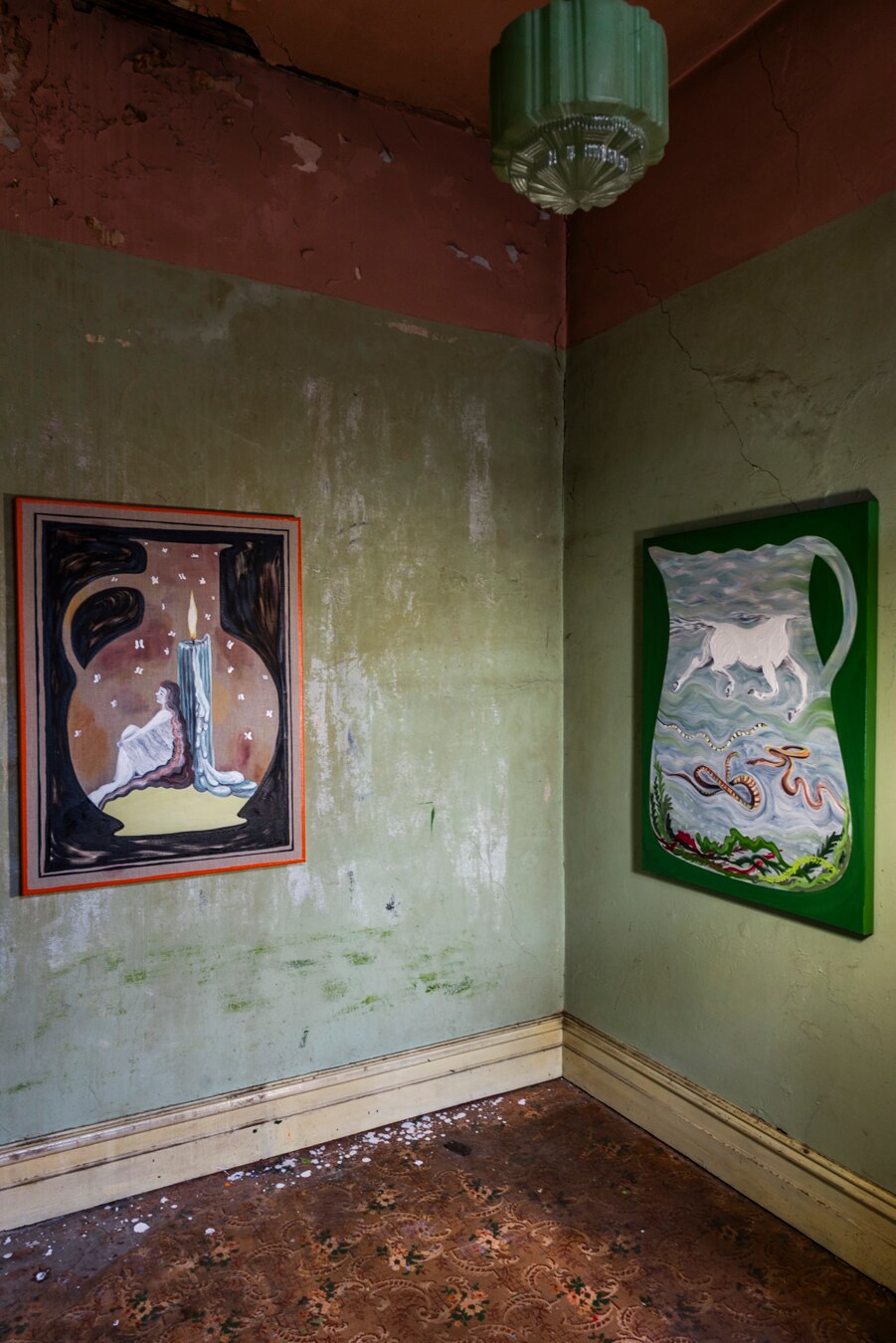 Two paintings hang in a derelict room 