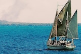 Old wooden sailing ship sailing away from camera toward the mangroves on a nice day.