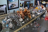 A row of model motorcycles sit on top of a counter.