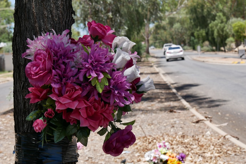 Flowers tied to a tree, mark the memorial site for the victim of fatal hit and run in Alice Springs in May 2022