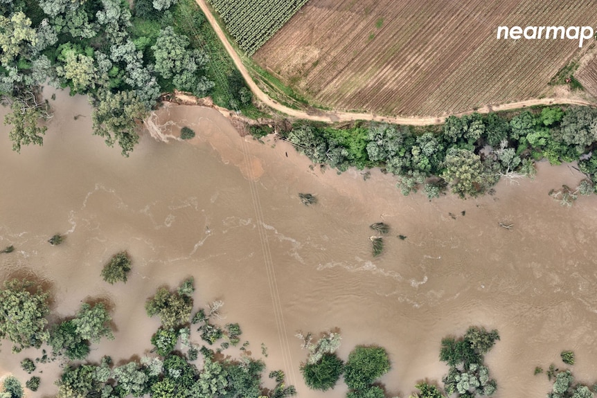 A birds eye view of a flooded river surrounded by trees.