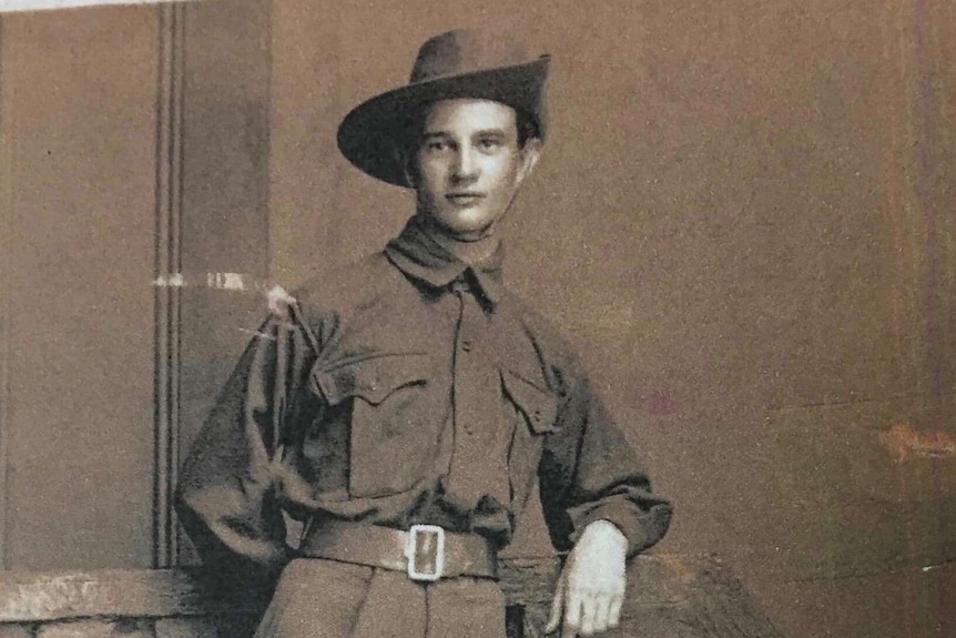 Private Cecil Burns in his Army uniform standing near a wall