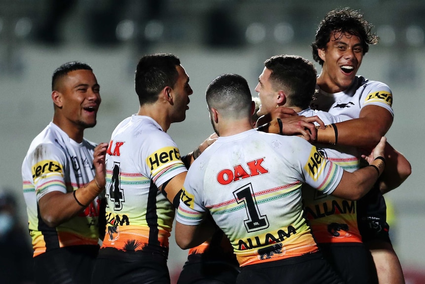 Penrith Panthers NRL players embrace as they celebrate a try against Manly.