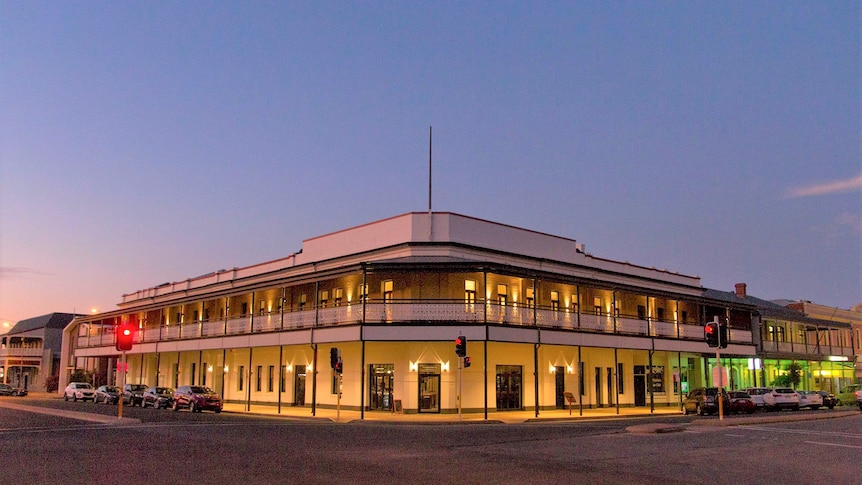 The Broken Hill Pub at sunset with lights on inside the building