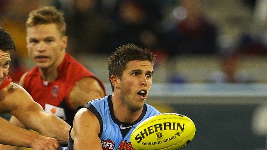 Marc Murphy (31 touches) handballs under pressure from the Dees.