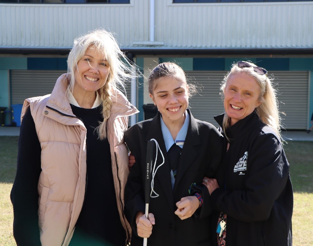 Two women standing with a teenage girl in the middle