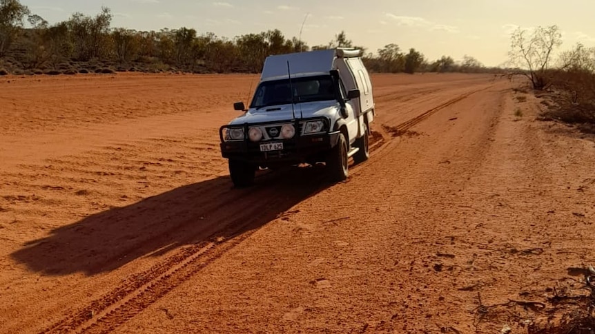 A 4WD vehicle on a red road through Central Australia