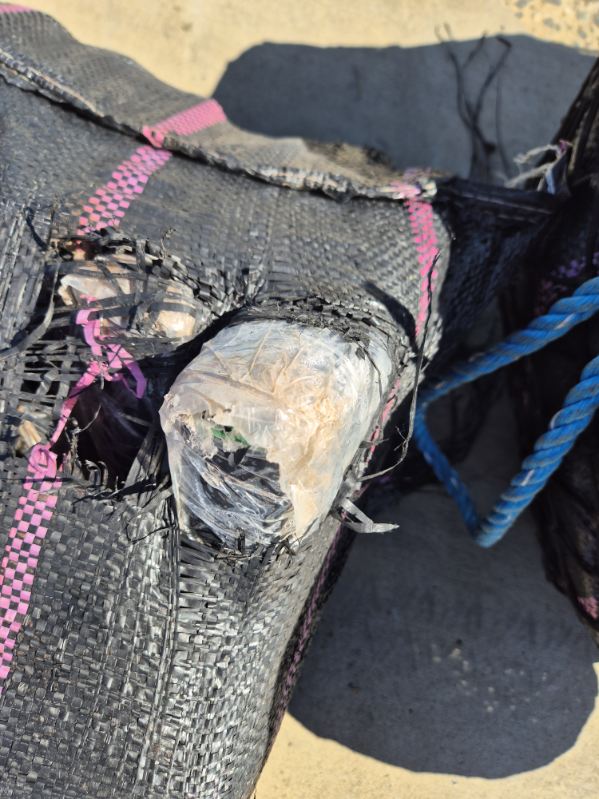 Un paquete roto que contiene un ladrillo de cocaína.