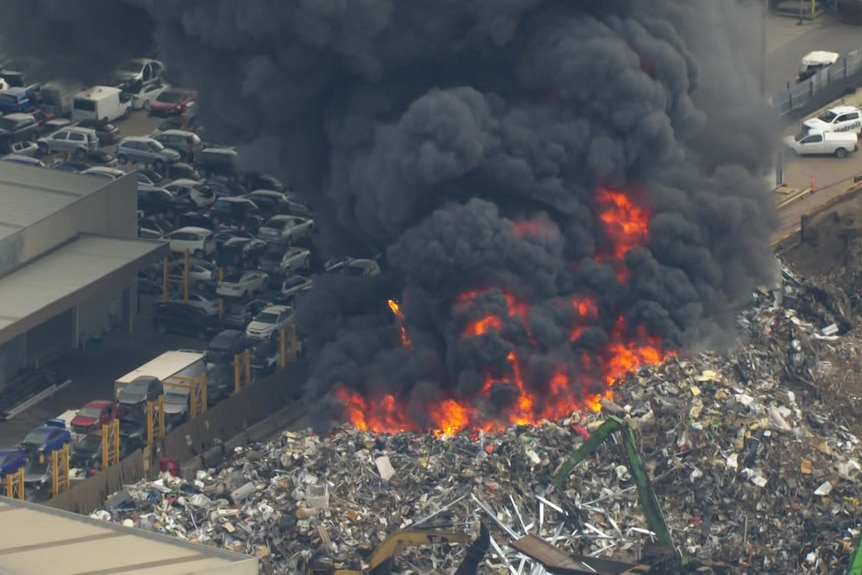 Smoke rising from a blaze on a pile of recycled trash.