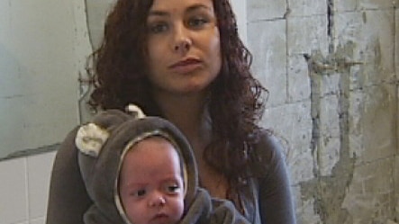 Tammy Cummings with her baby in the unfinished bathroom