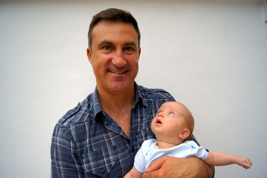 A mid-range photo of Dave Fitzgibbon and his baby son Harvey looking up at him.