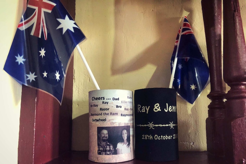 Two stubby holders sit with Australian flags on a pub shelf