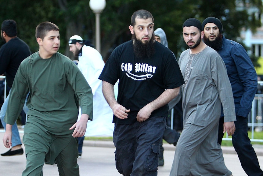 A group of protesters, one wearing a '6th Pillar' shirt, demonstrate against an anti-Islamic film in Sydney