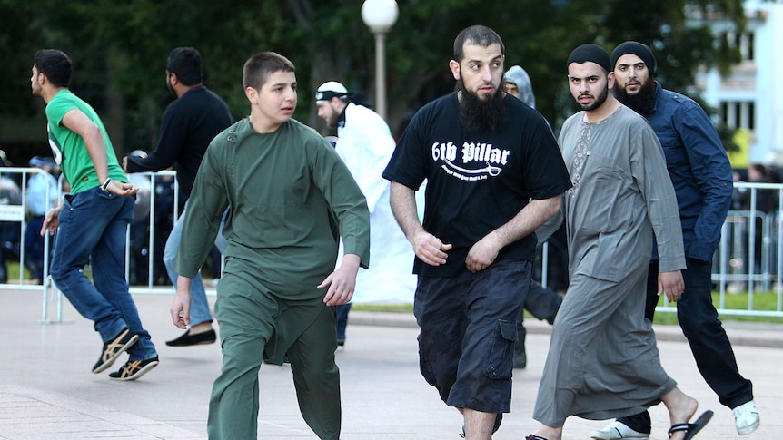 A group of protesters, one wearing a '6th Pillar' shirt, demonstrate against an anti-Islamic film in Sydney