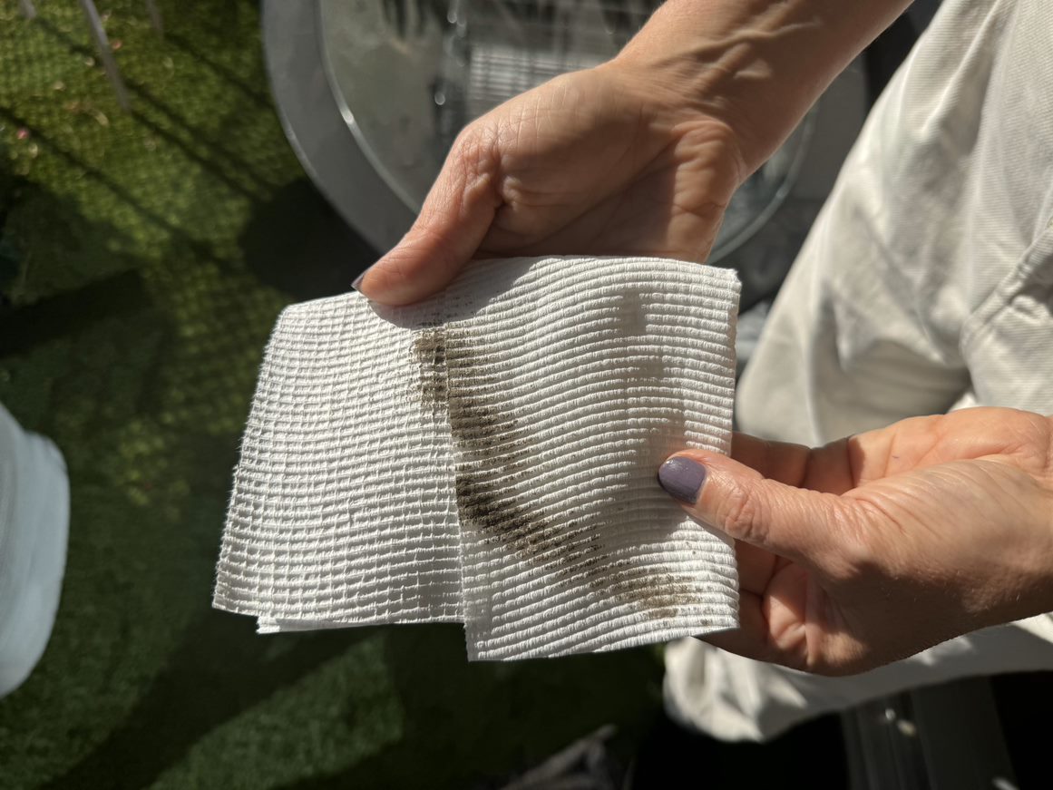A folded paper towel with brown smears of grime and dirt.