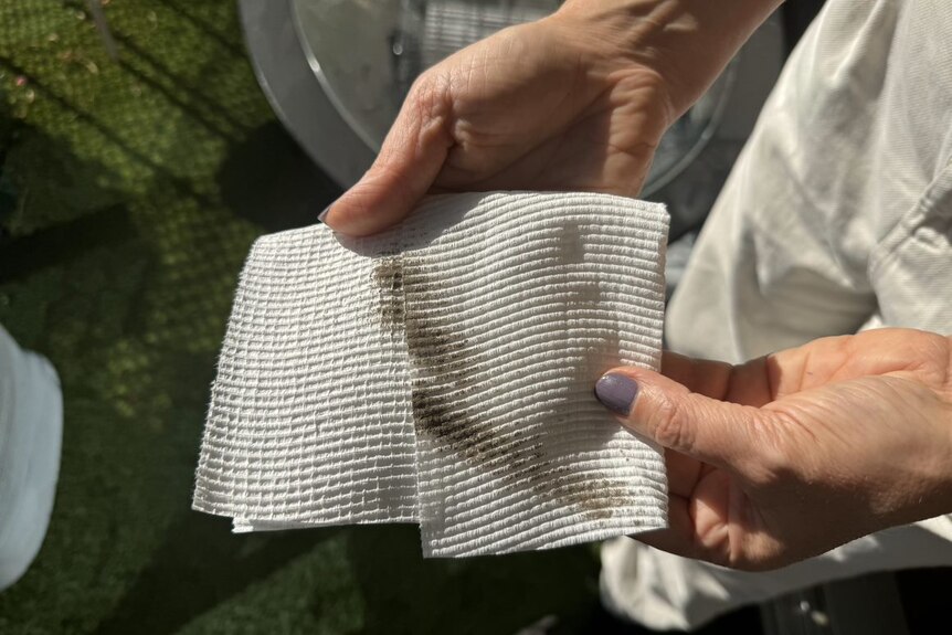 A folded paper towel with brown smears of grime and dirt.