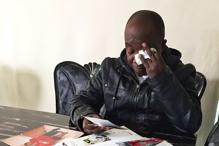 Etiene Ndikuriyo looking at photos of his son