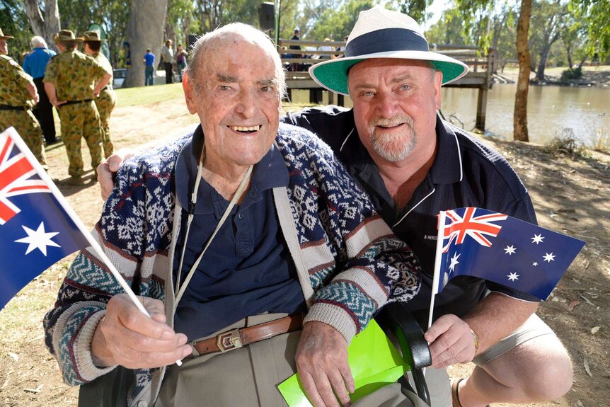 John 'Jack' Thomas with his son Neil both holding Australia flags at an awards ceremony in Echuca.