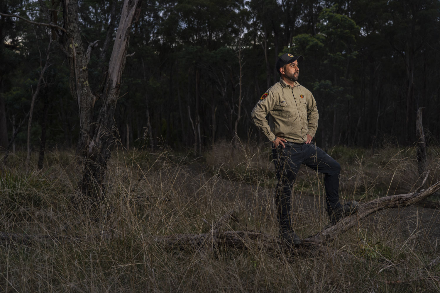 Joel Williams stands in a grassy area near gum trees.