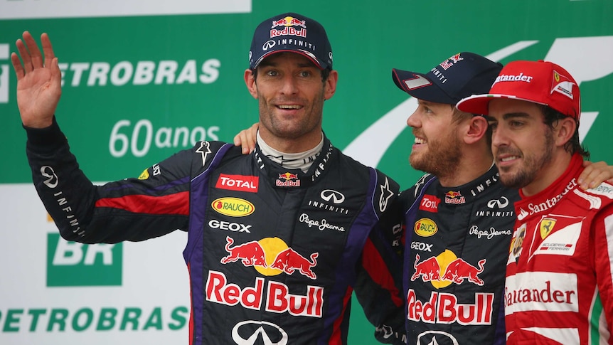Australian Mark Webber (L) waves to the crowd on the podium after the Brazilian Grand Prix.
