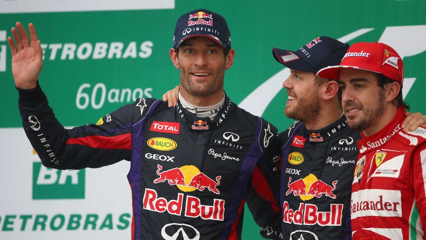Australian Mark Webber (L) waves to the crowd on the podium after the Brazilian Grand Prix.