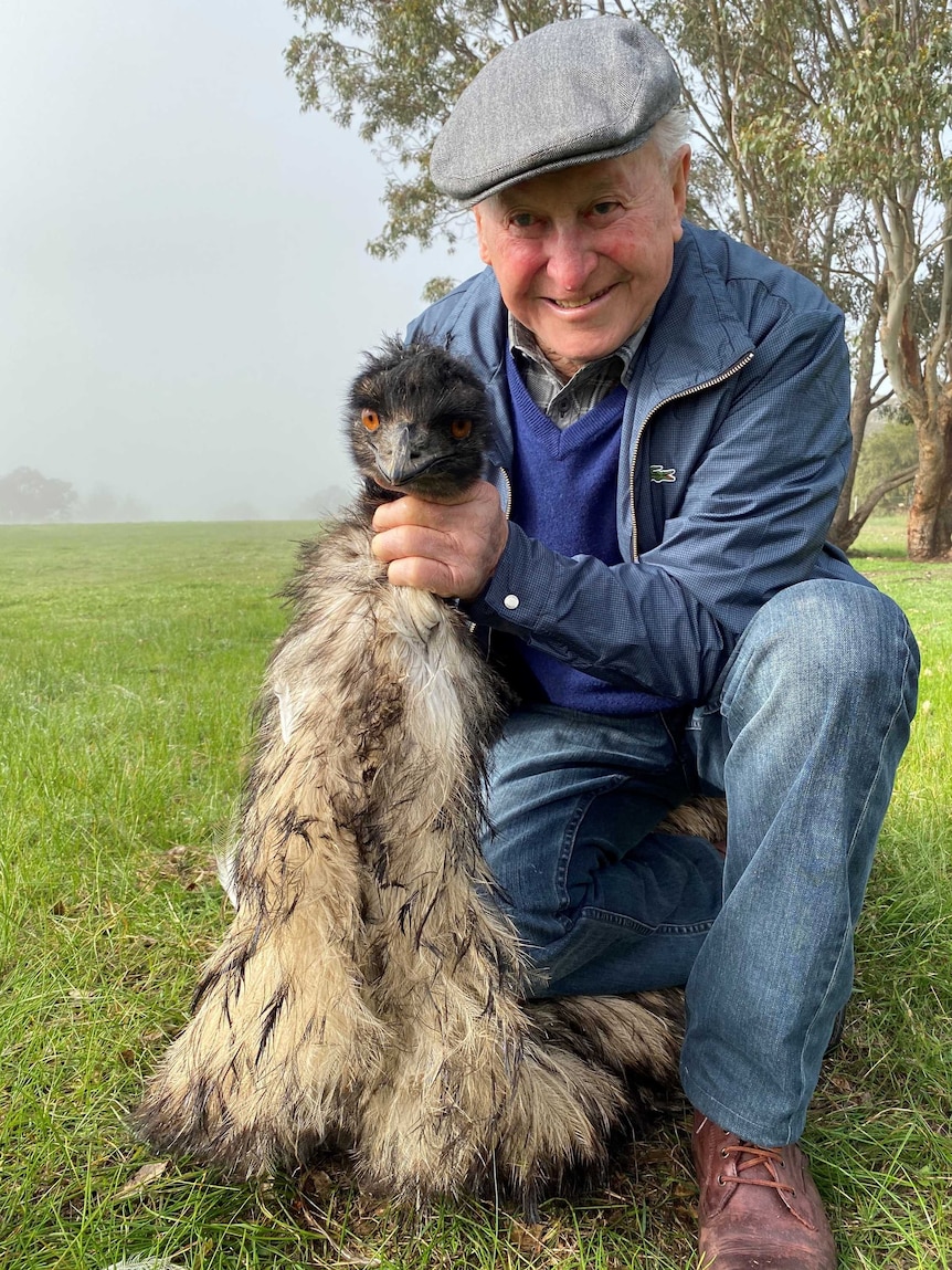 Man kneeling with emu.