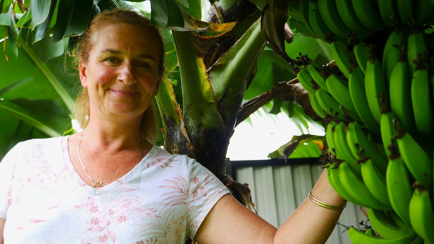 woman smiling next to bana tree