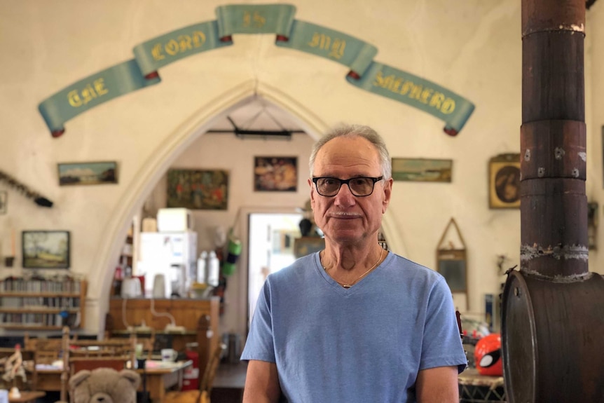 Norbert Scholz standing inside his home, which was once a Lutheran Church, with lots of memorabilia.