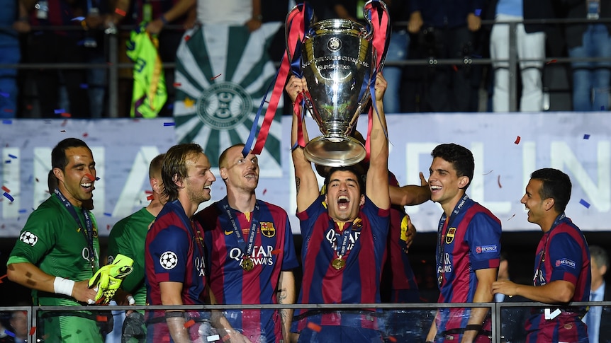 Barcelona's Luis Suarez lifts the Champions League trophy after his team's win over Juventus.