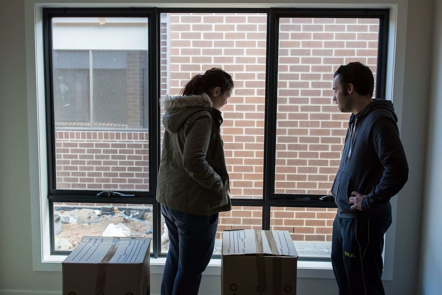 Nicki and Matt look out the window of their home.