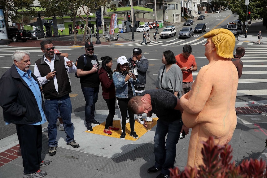 Passers-by inspect naked Donald Trump statue in Los Angeles