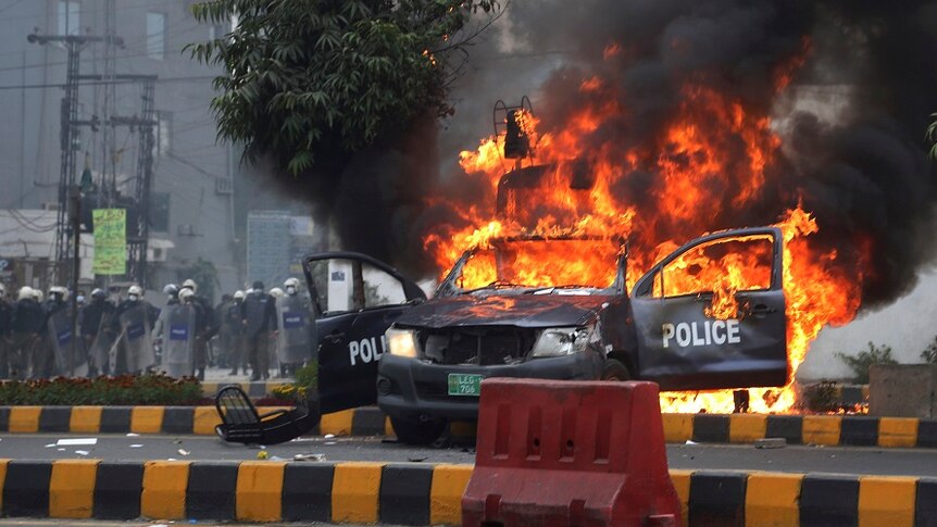 A police car is set on fire.