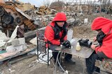 Workers repair fibre optic cable in the ruins of Irpin near Kyiv