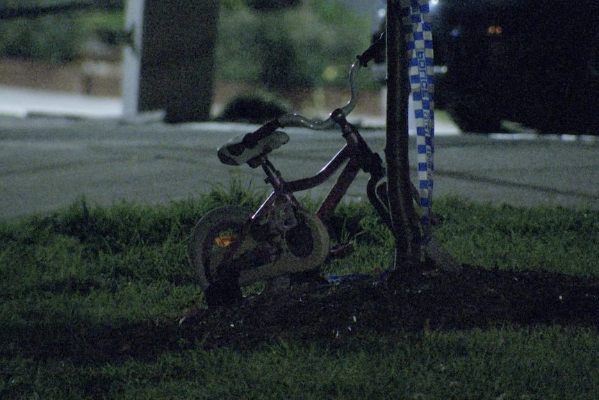 A children's bicycle with police tape nearby