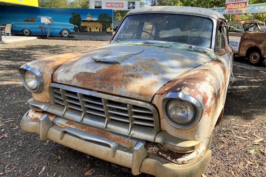 Rusted old Holden car in foreground, other older cars in the background