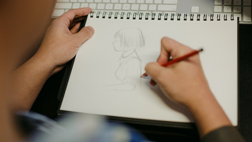 Colour photograph of games designer Ken Wong sketching Florence, the hero of his mobile game of the same name.