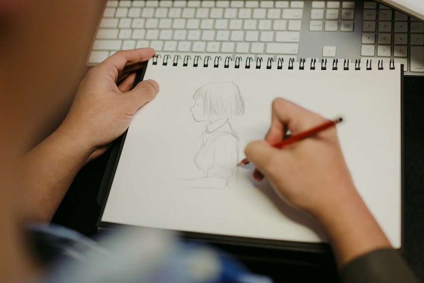 Colour photograph of games designer Ken Wong sketching Florence, the hero of his mobile game of the same name.