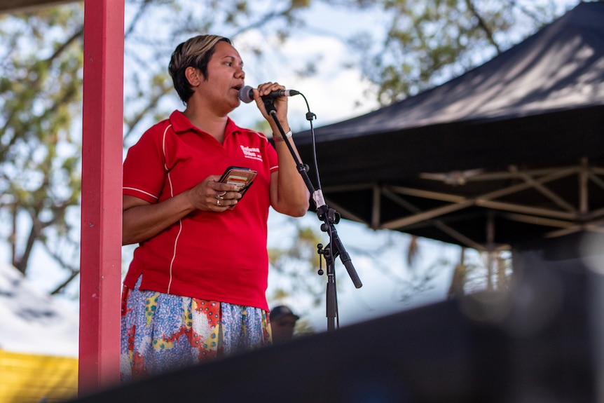 A minister addresses the crowd at barunga on a stage. 