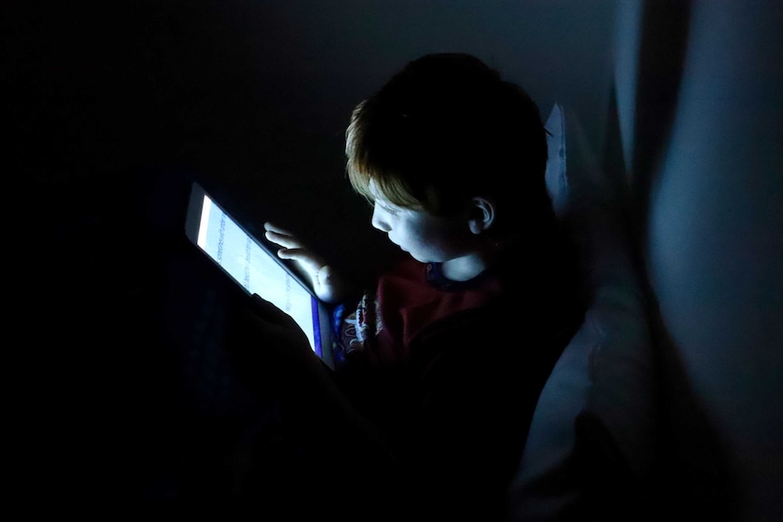 A child scrolls through a tablet.