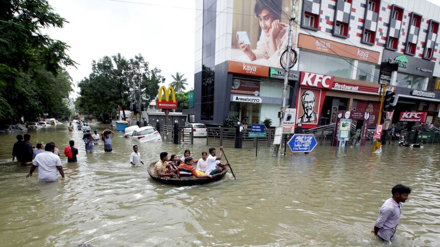 Residents make their way through flooded Chennai street