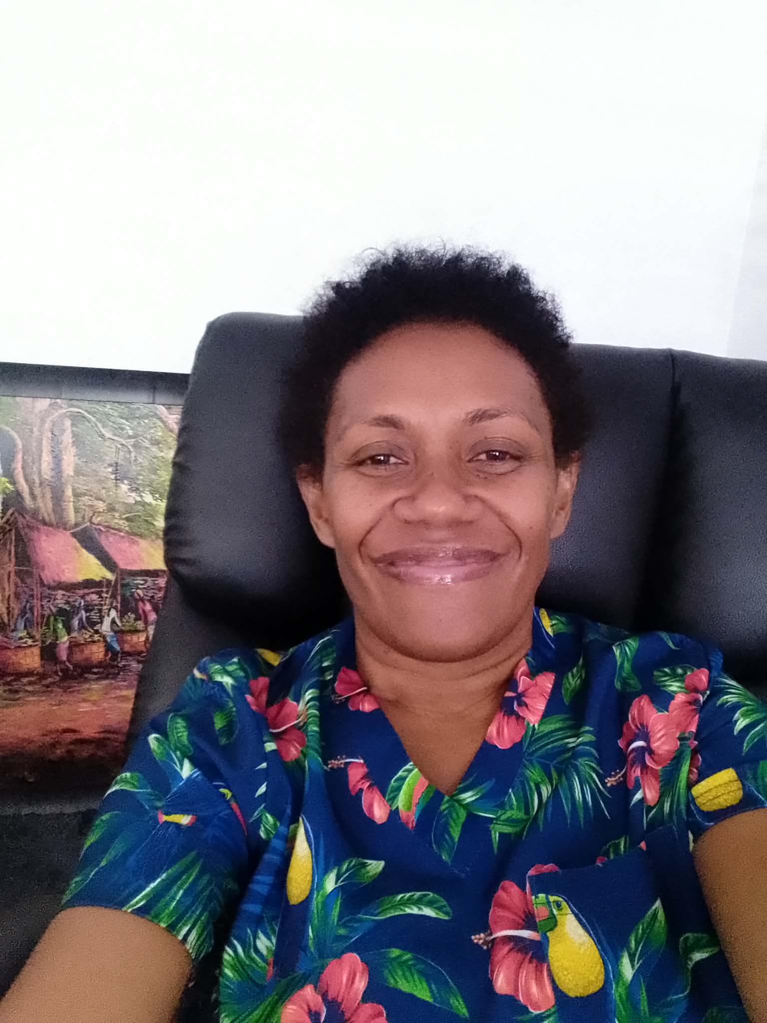 A woman in a colourful shirt smiling 